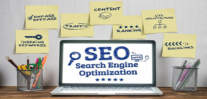 A computer screen surrounded by sticky notes emphasizing the many benefits of properly utilizing Search Engine Optimization.