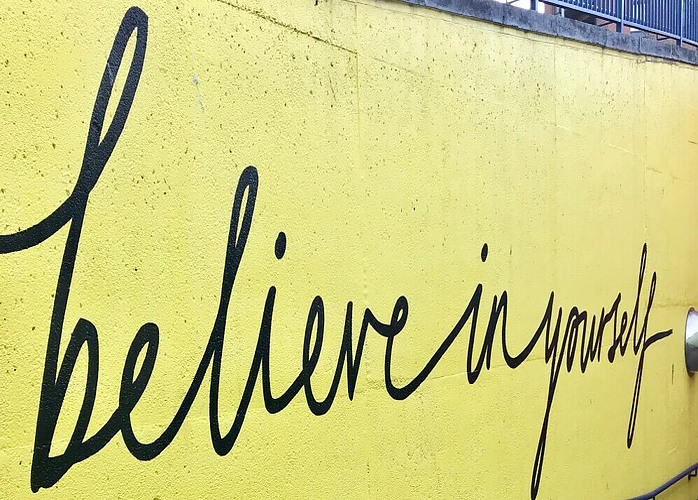 believe in yourself written on a yellow wall