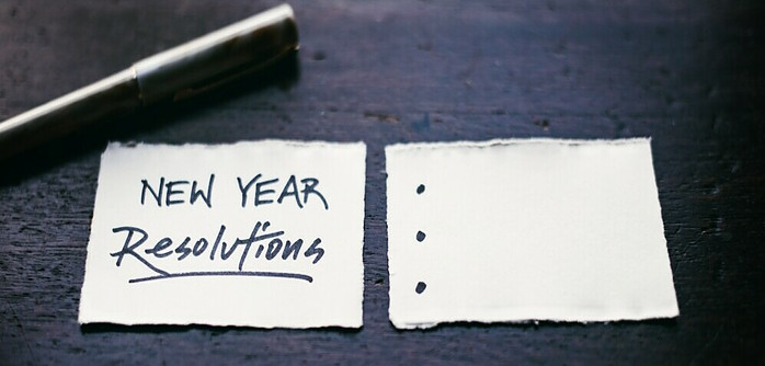 New Year Resolutions written on paper with a pen to add yours