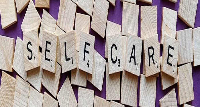 scrabble letters spelling out self care