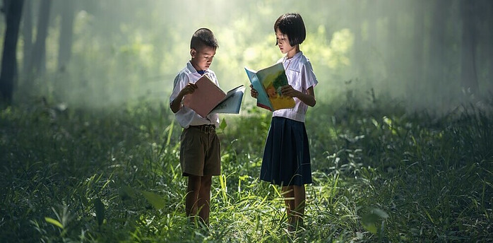 two kids reading in the forrest showing that continuous learning can happen in any environment