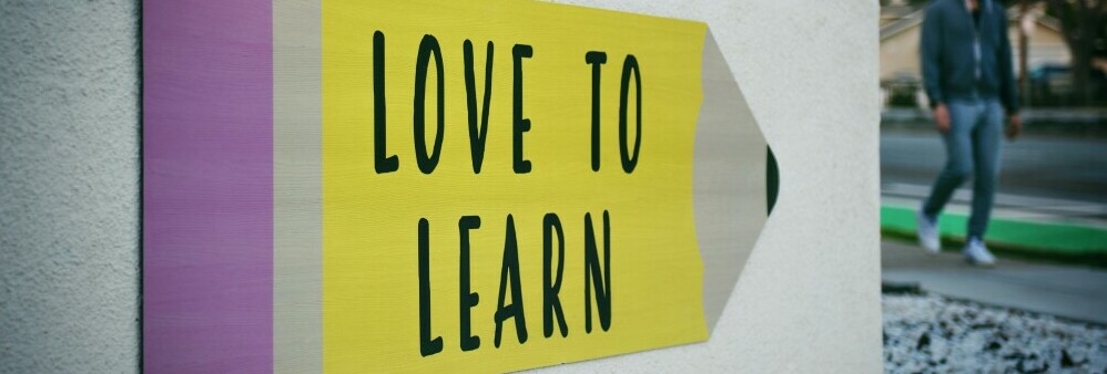 a sign that says love to learn in a pencil shape