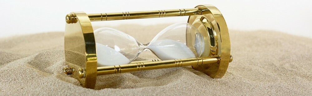 an hour glass in the sand to emphasize the importance of time