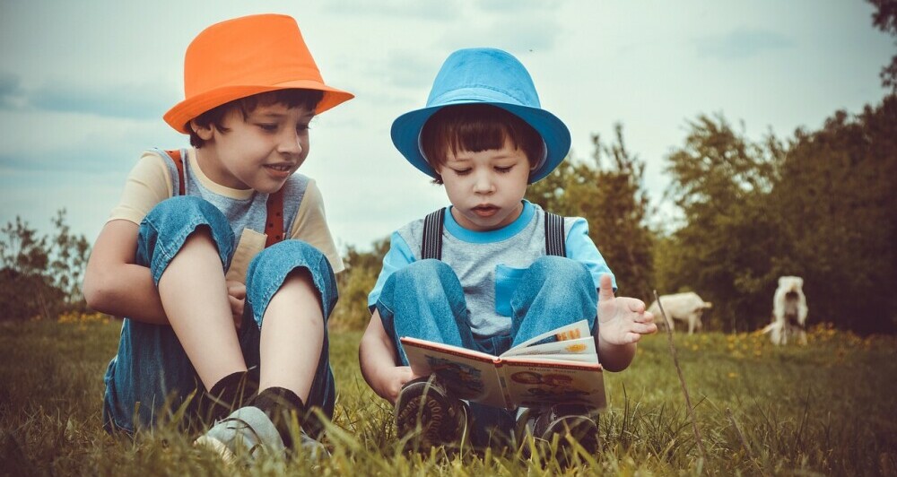 two children reading a book to get story time in